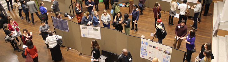 Attendees interacting with poster presenters at Community-Driven Research Day.