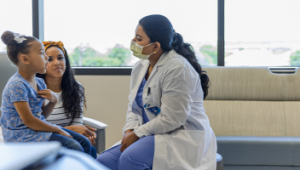 A female doctor engaging with two children in the hospital