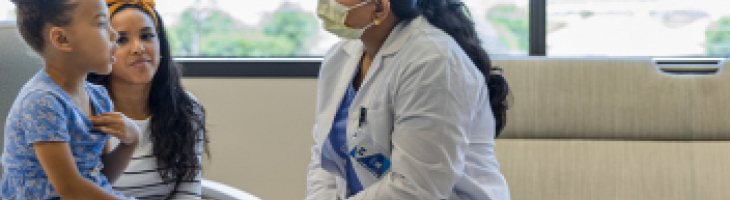 A female doctor engaging with two children in the hospital